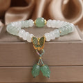 Tian Shan Cui green crystal abacus beads bracelet with butterfly tassel, pearls, and rhinestones on white background