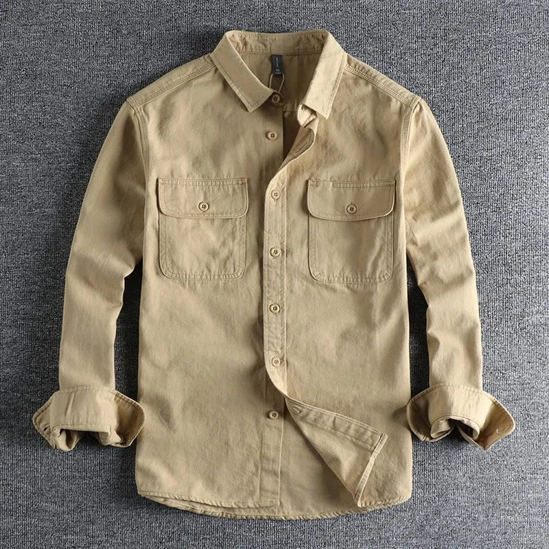 A man wearing a loose fit light grey long sleeve polyester cardigan shirt