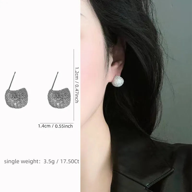 Gold and white drop-shaped geometric earrings with sphere elements and sparkling crystals