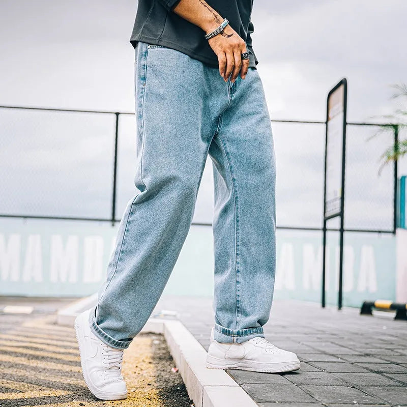 Men's loose straight fit casual jeans in dark blue cotton fabric, showing mid waist and zipper fly.