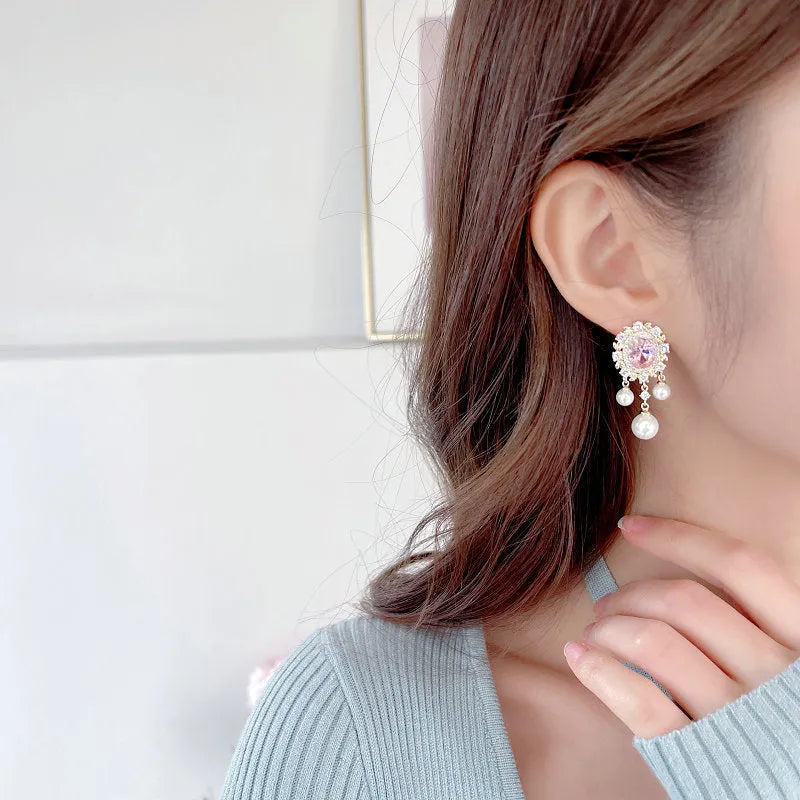 Oval geometric copper earrings with inlaid zircon centre and white pearl tassel drop in light purple colour.