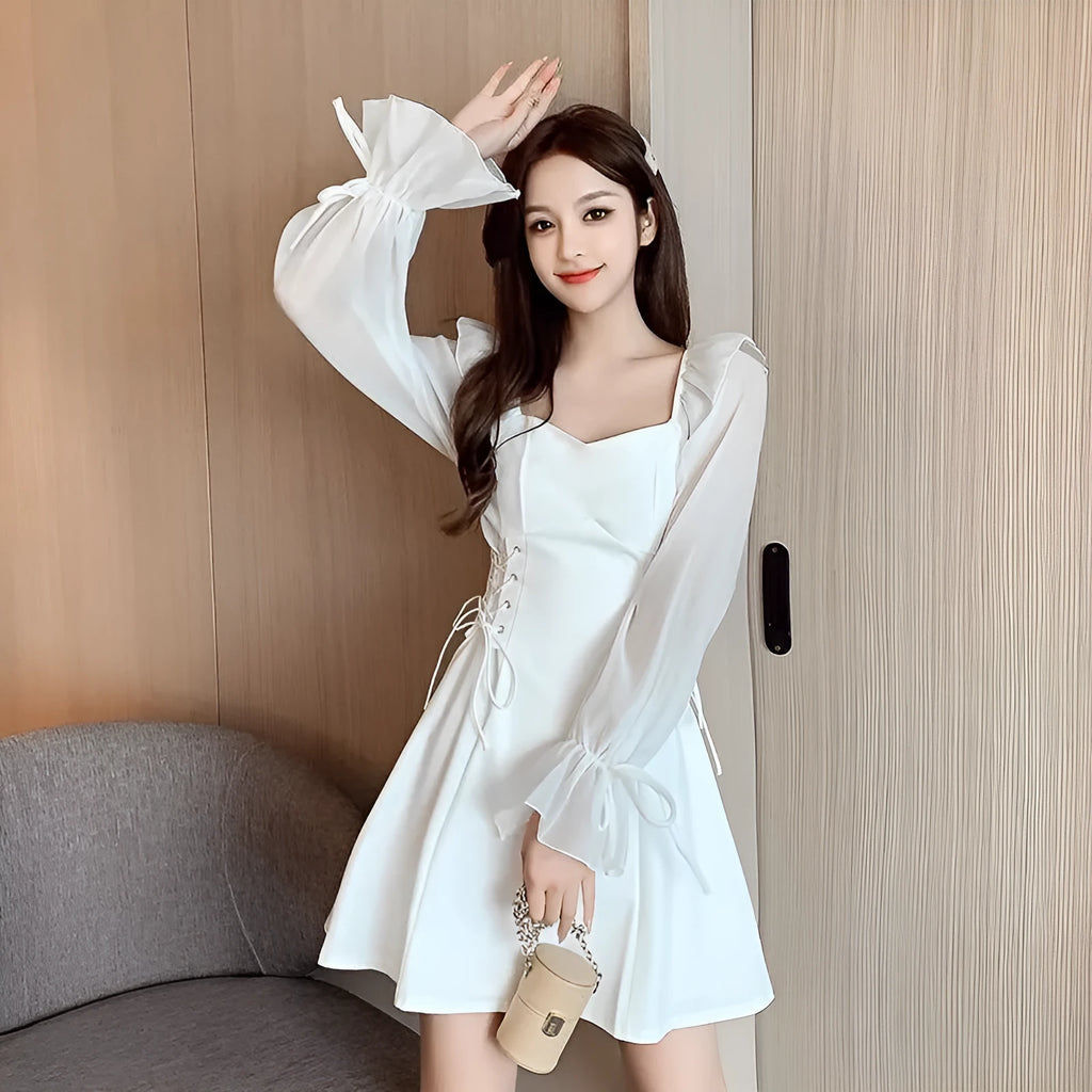 White women's chiffon dress with patchwork detail, long sleeves, and a long slimming skirt.