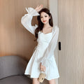 White women's chiffon dress with patchwork detail, long sleeves, and a long slimming skirt.