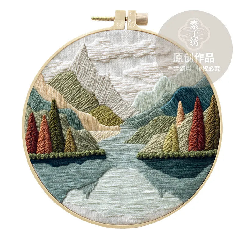 Embroidery kit with printed landscape design fabric, coloured thread, needles, and bamboo frame
