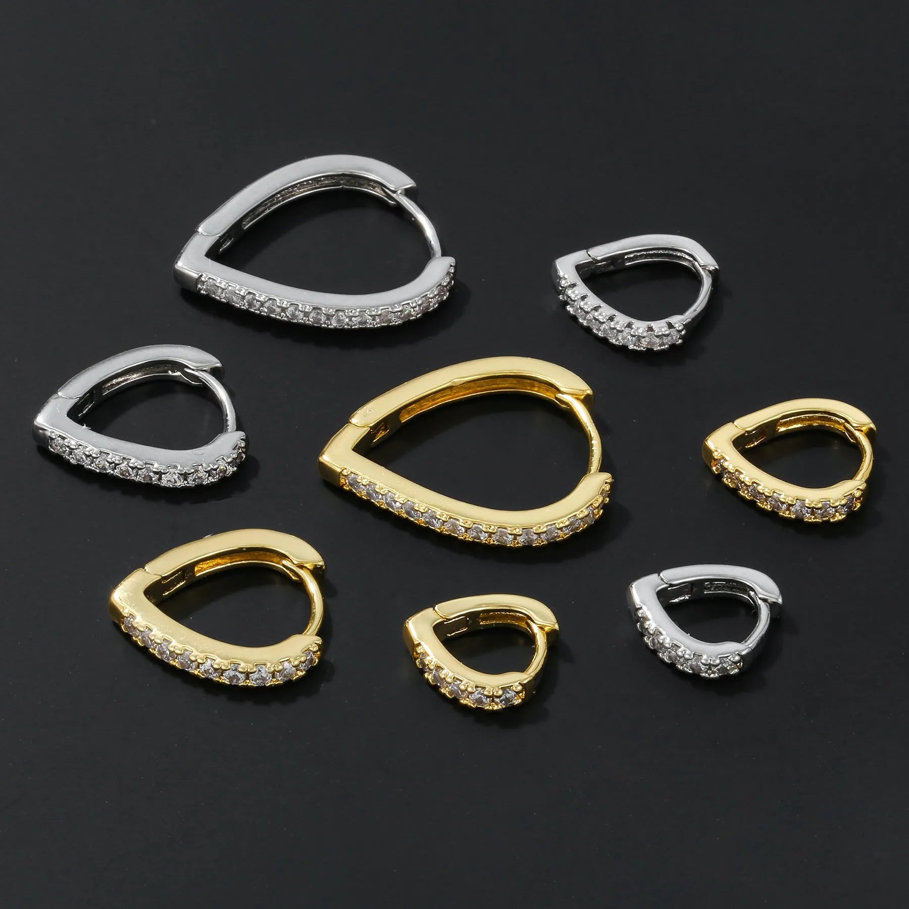 Geometric gold tone love heart clip-on earring for women on a white background.