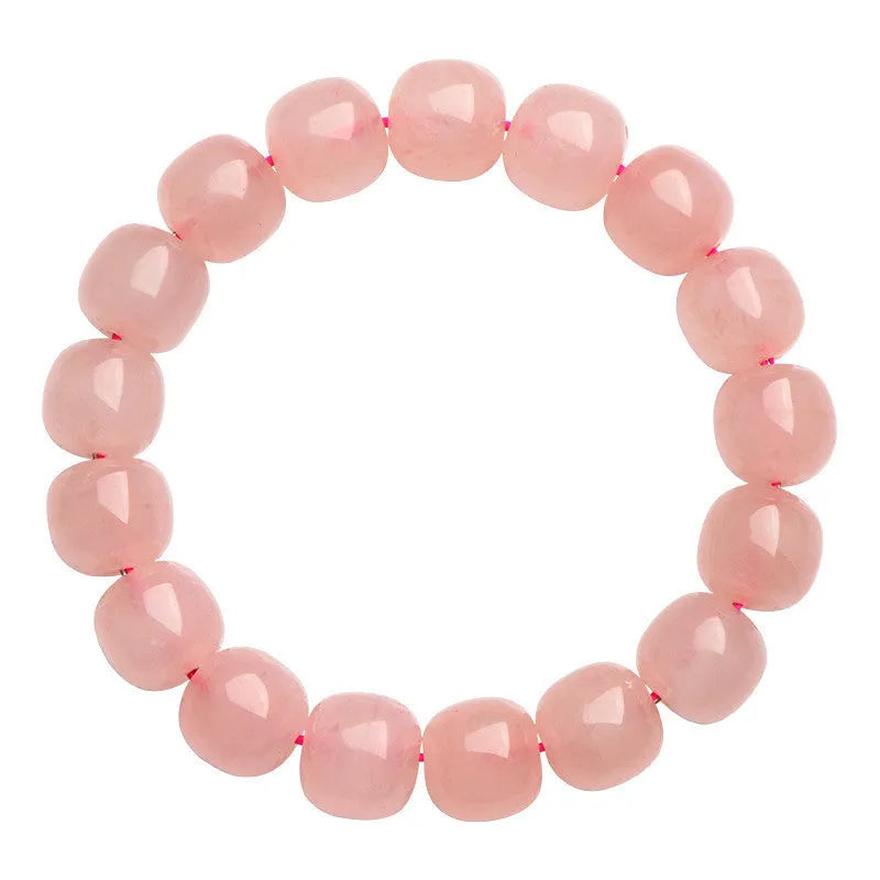 Pink natural crystal bracelet with polished geometric barrel-shaped beads on a wrist.
