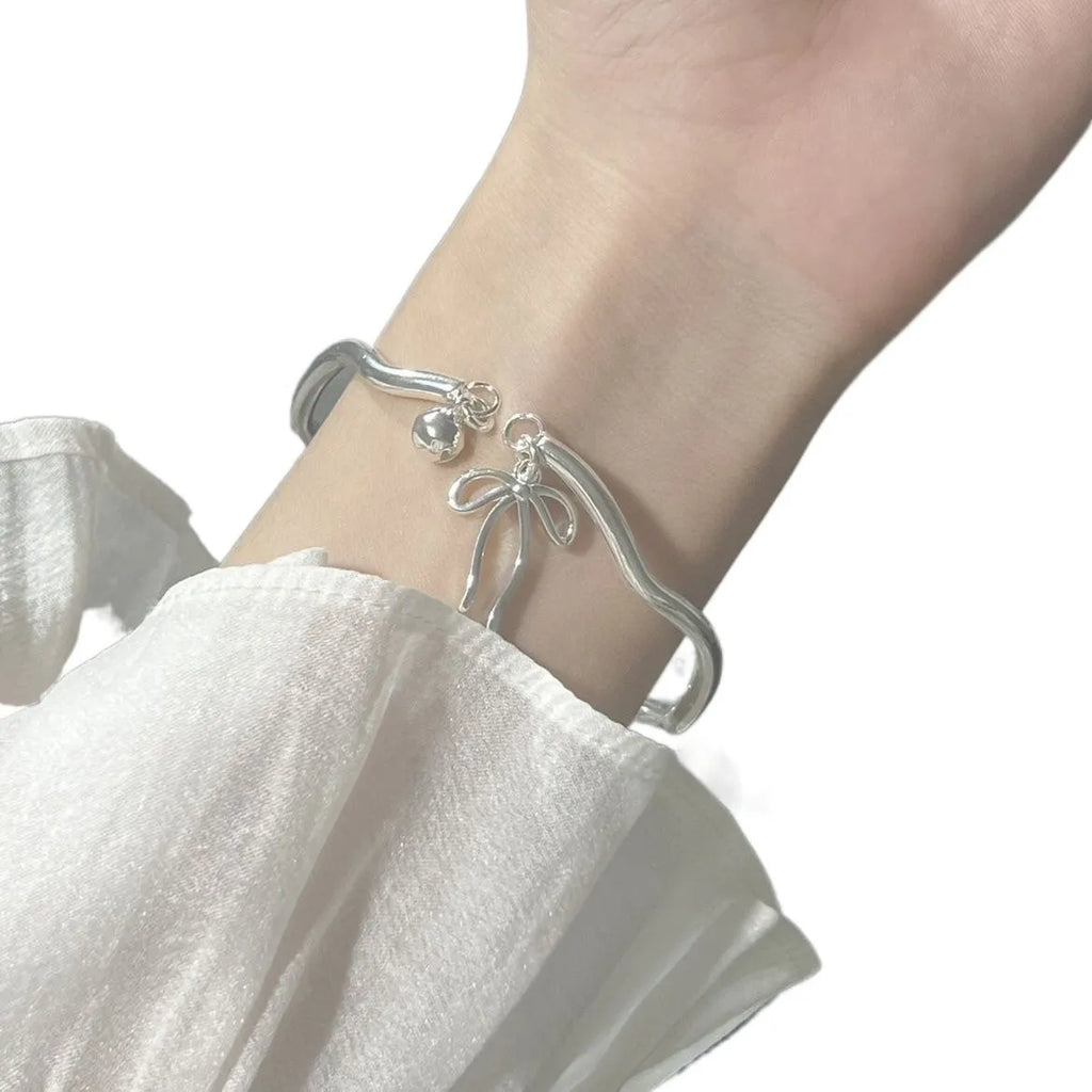 Adjustable silver bracelet with bow design and opening clasp on zinc alloy base