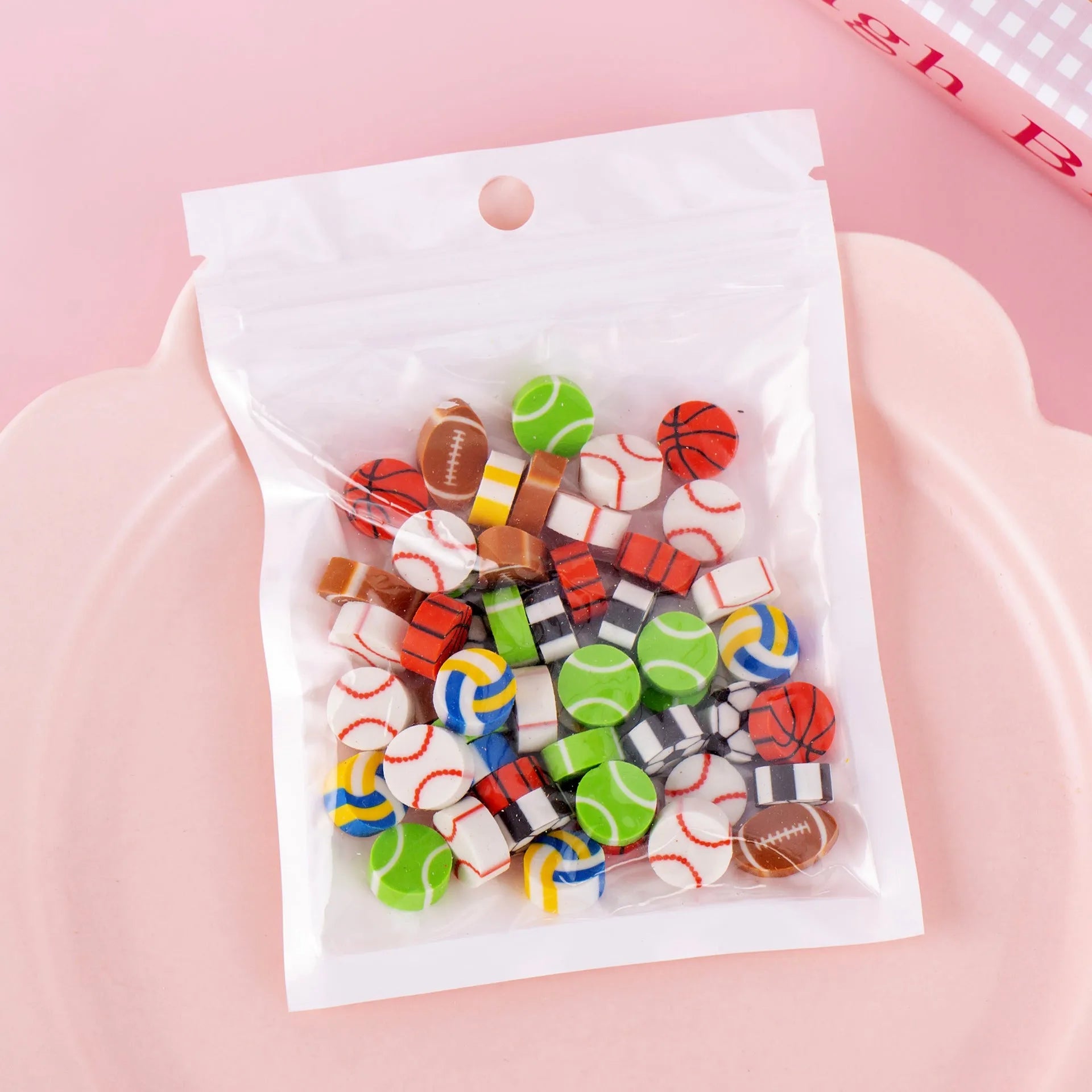 50 small colourful cartoon novelty erasers including fruit and animal shapes in a pearlescent film bag.