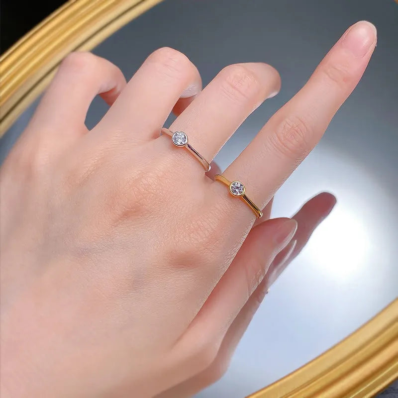 Minimalist crown-shaped silver ring with line detailing on a white background.