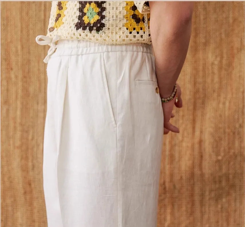 Straight-leg linen trousers in greige colour with a high elasticated waistband on a hanger.