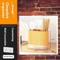 Plastic wall-mounted chopstick holder in beige with drainage holes, containing chopsticks and spoon