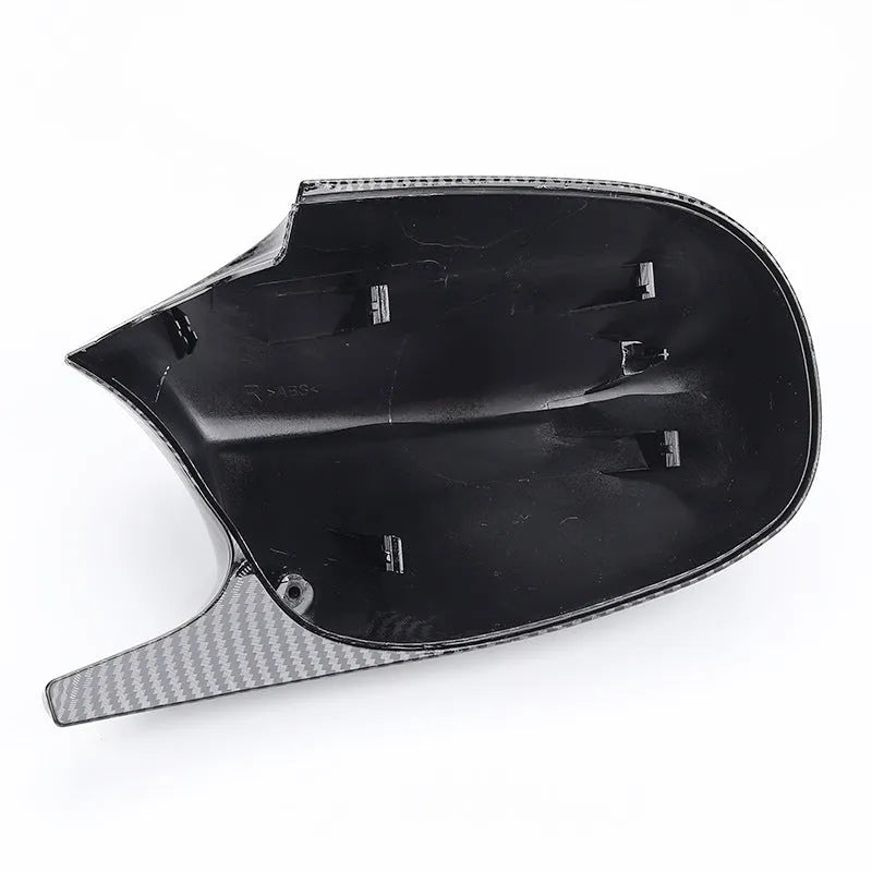 A pair of black and carbon pattern ABS plastic rearview mirror housing shells for a BMW 3 Series E90.