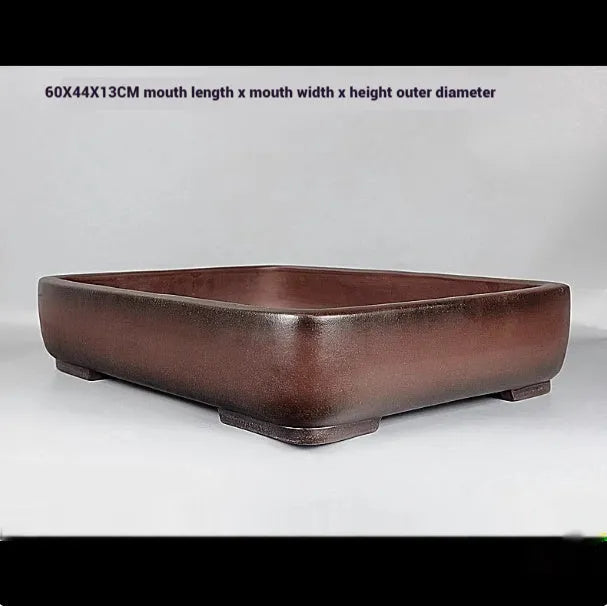 Handmade antique rectangular purple clay flower pot for plants on a tabletop.