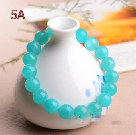 Polished Amazonite scattered beads in ice colour with size options for jewellery making next to crystal bracelet