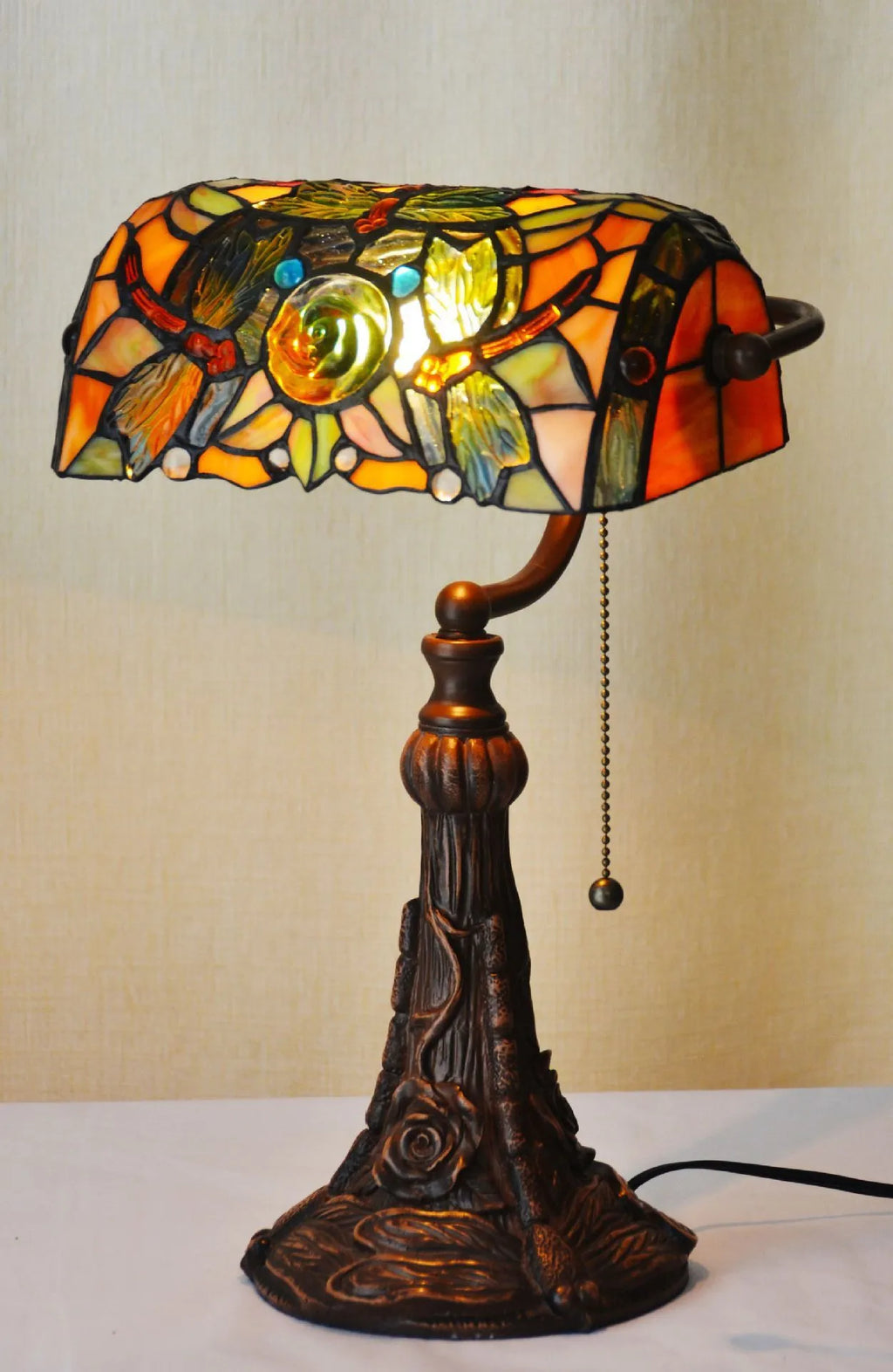 10-inch Tiffany table lamp with coloured glass shade and resin base on a desk.