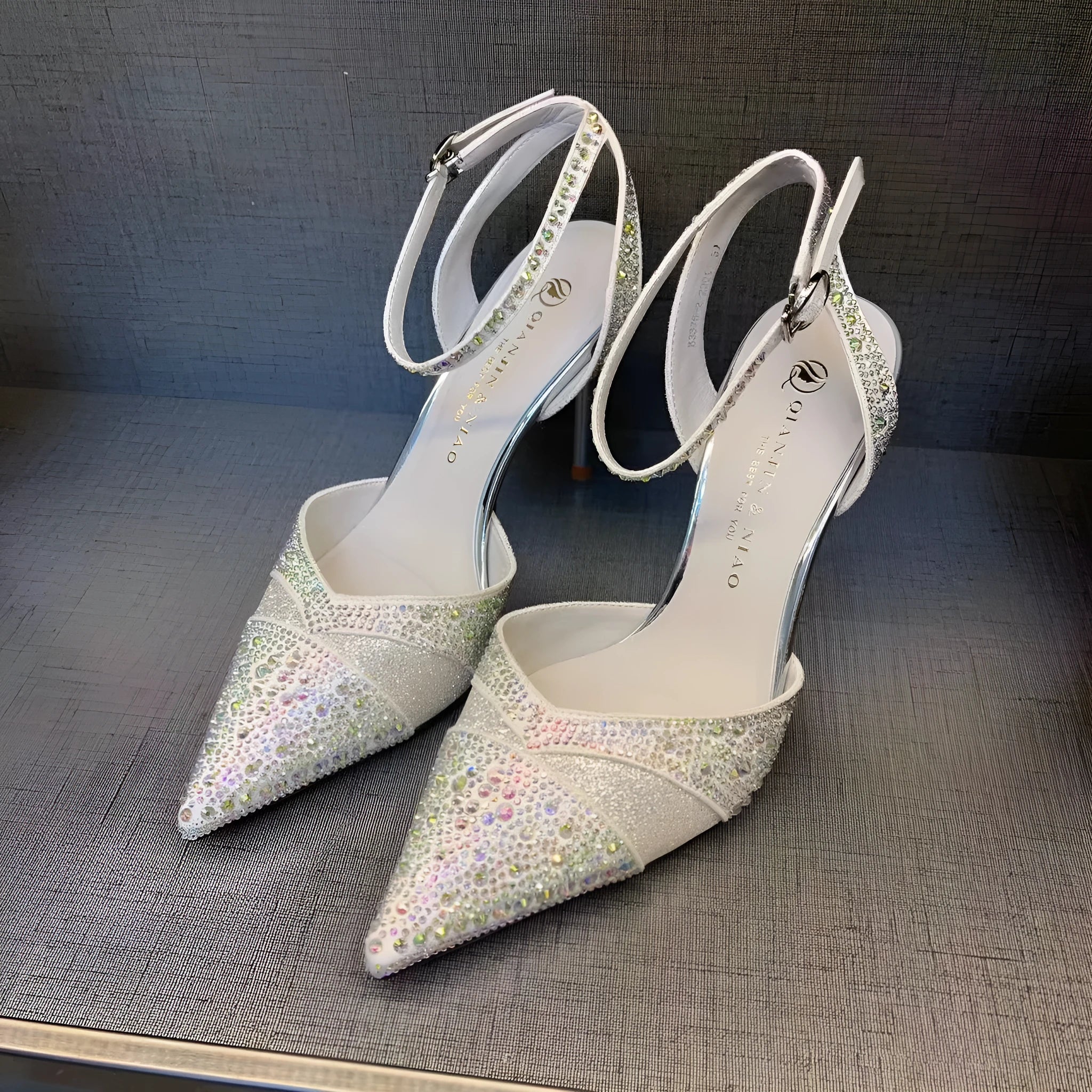 Women's black hollow high heel with stiletto heel, pointed toe, and red sole on a plain background.