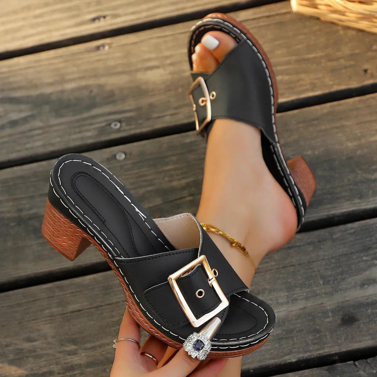 Women's black chunky heel slippers with a silver metal buckle fastening on the strap