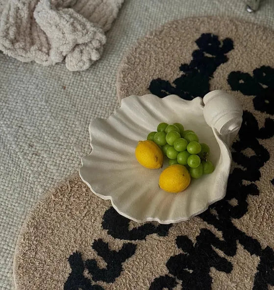 White resin simulation shell storage fruit plate ornament on a plain background.