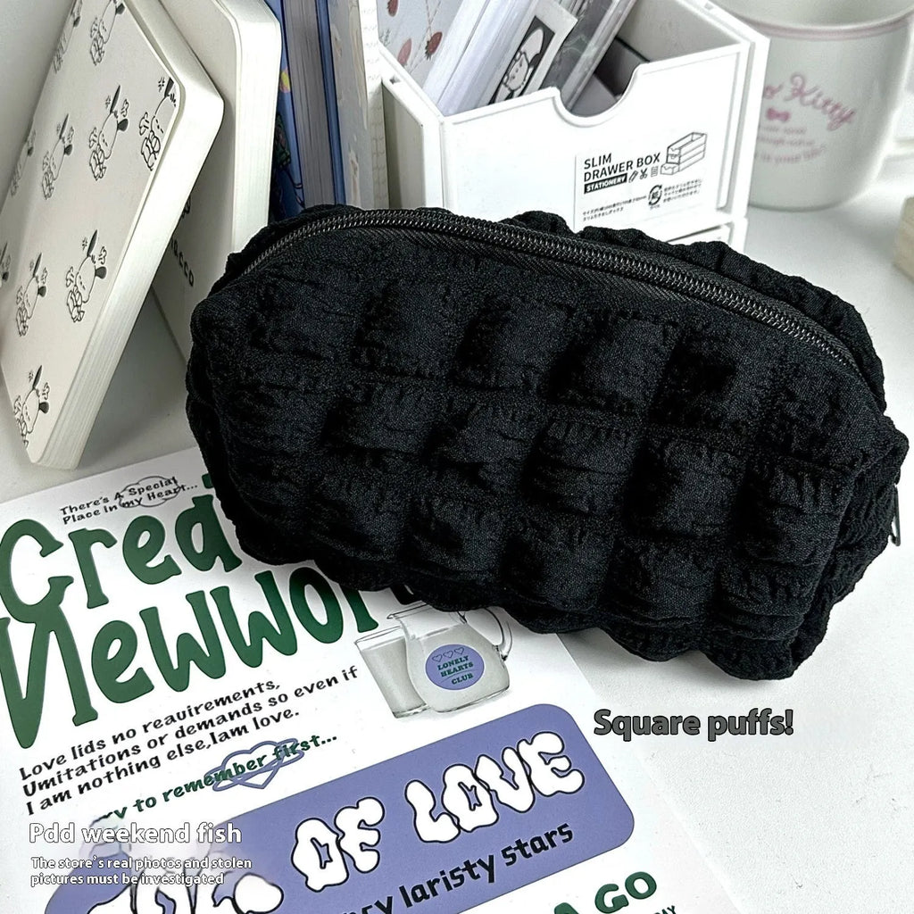 Beige and black fabric pencil case with cream puff design for pen storage