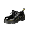 Women's white lace-up leather shoes with thick soles and black cross straps on the ankle.
