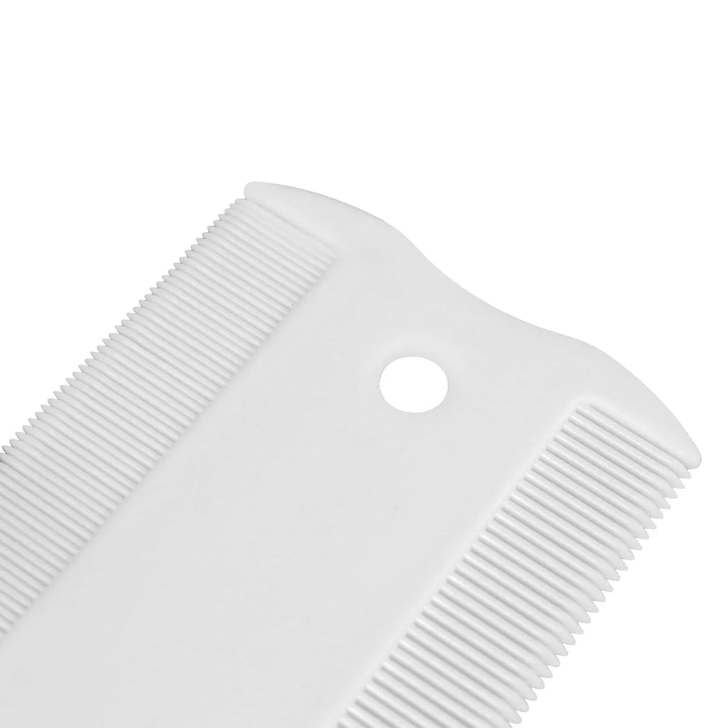 A small white plastic double-sided flea comb for pets, shown next to a ruler for scale.