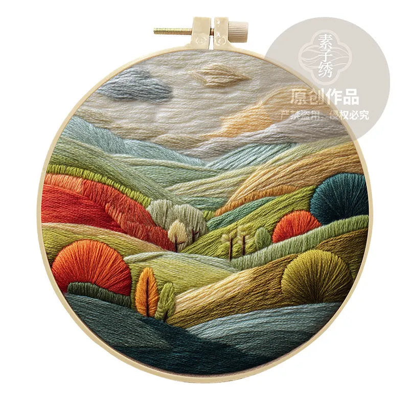 Embroidery kit with printed landscape design fabric, coloured thread, needles, and bamboo frame