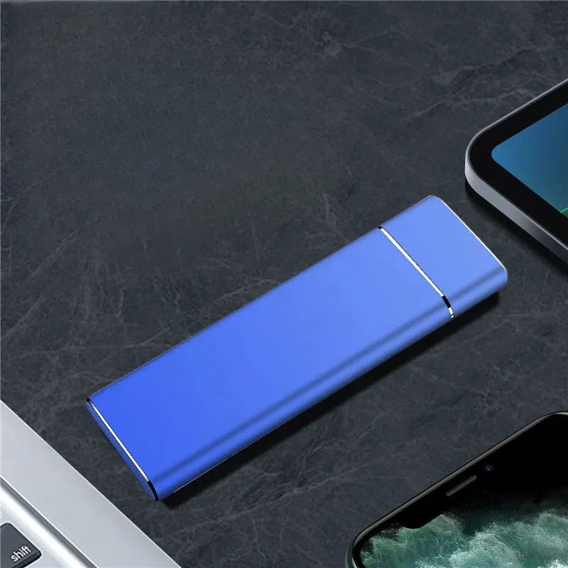 Sapphire blue portable external solid state hard drive with metal shell, shown next to its USB cable.