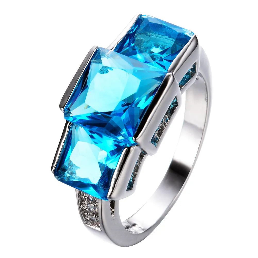 A selection of colourful electroplated copper rings in geometric designs, showing various sizes and hues.