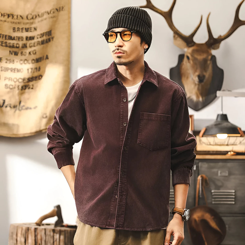 Man wearing a loose-fitting red corduroy shirt jacket with long sleeves.