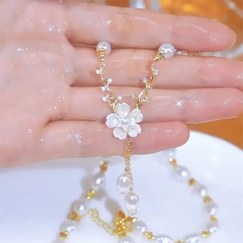 Women's alloy necklace with a white pearl flower and rose design pendant on a chain.