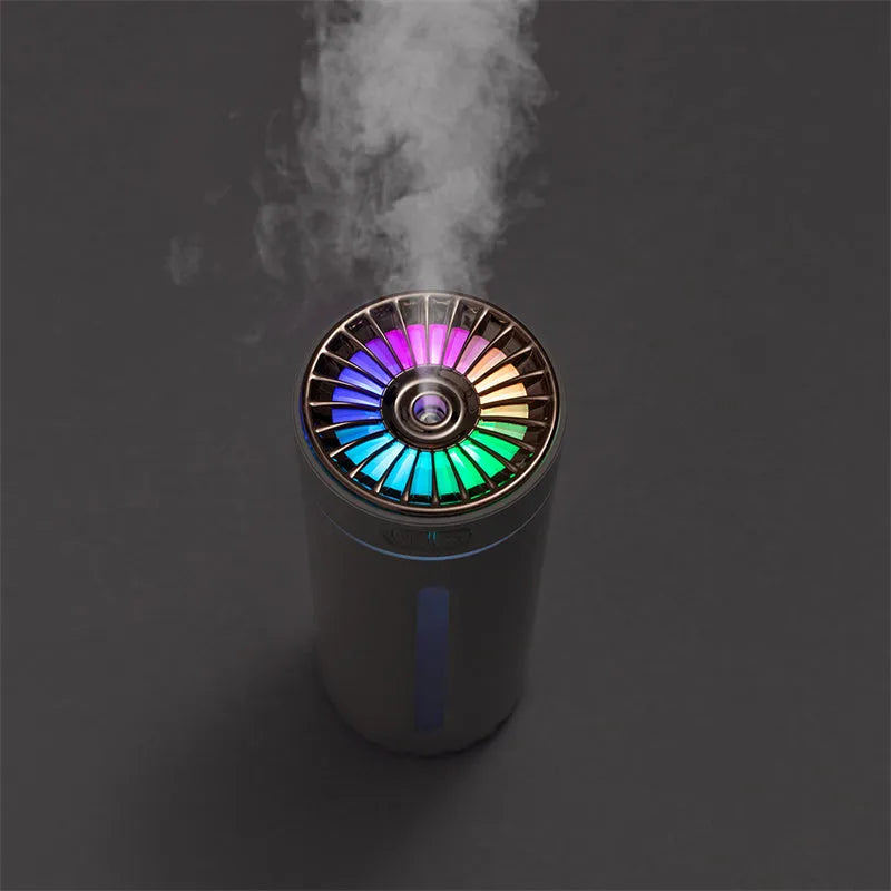 Black wireless ultrasonic humidifier with LED lights sitting in a car cup holder.