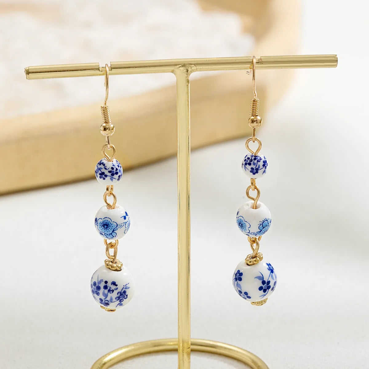 Blue and white porcelain ceramic beads long drop earrings on display with geometric round shape and alloy backing